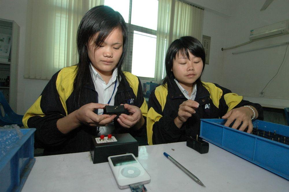 PÅ JOBB: Xie Bing Jis (til venstre) jobb består i å feilsøke på høyttalere som av en eller annen grunn ikke fungerer. Her sammen med en kollega.