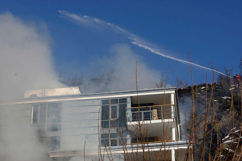 GASSFARE: Brannvesenet sprøytet onsdag formiddag vann på boligblokken som kollapset i Ålesund natt til onsdag. En lekk gasstank i kjelleren gjorde at faren for eksplosjon var stor.