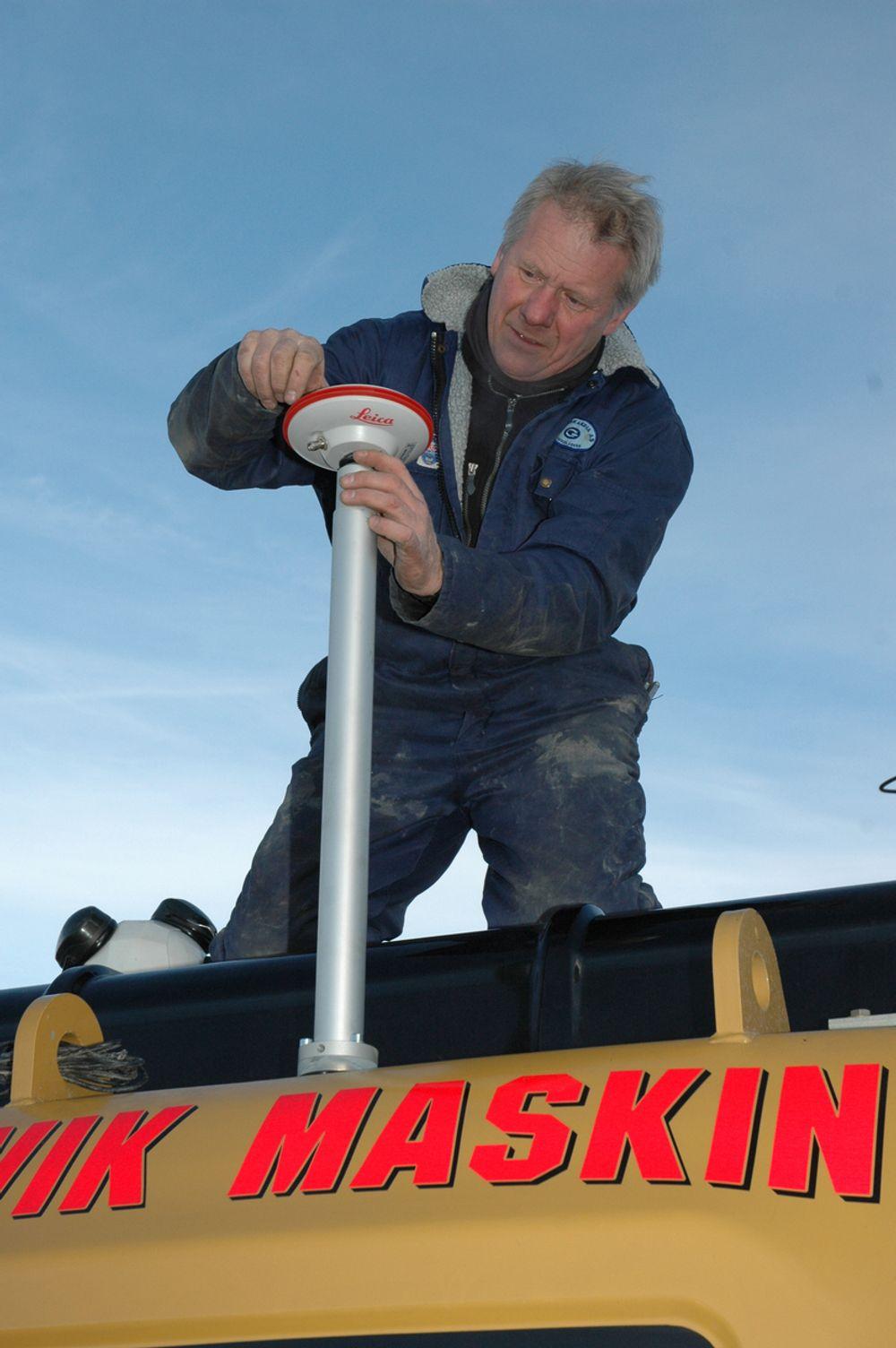Jan Floberg, daglig leder i Gundersen og Løken Instrumnter AS monterer GPS-antenne på en gravemaskin.
