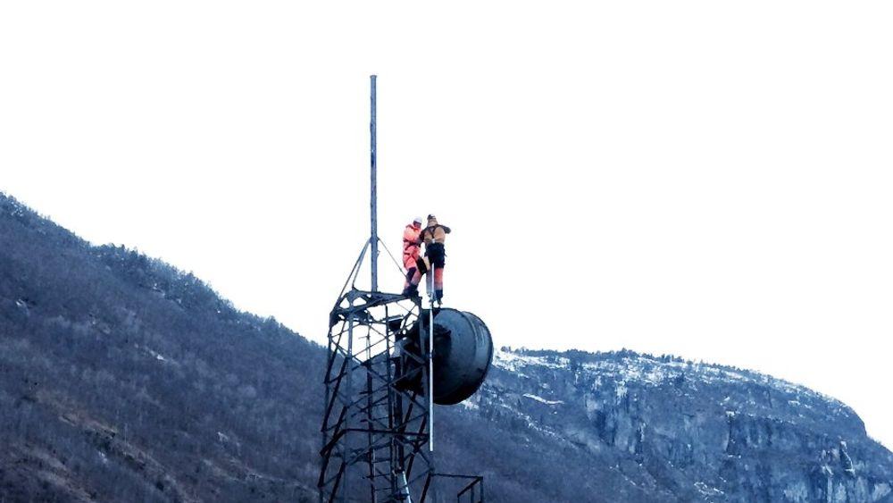 Mannskap fra Eltel strekker kabler fra Telenors mobile container og opp i mobilmasten som overlevde storbrannen i Lærdalsøyri.