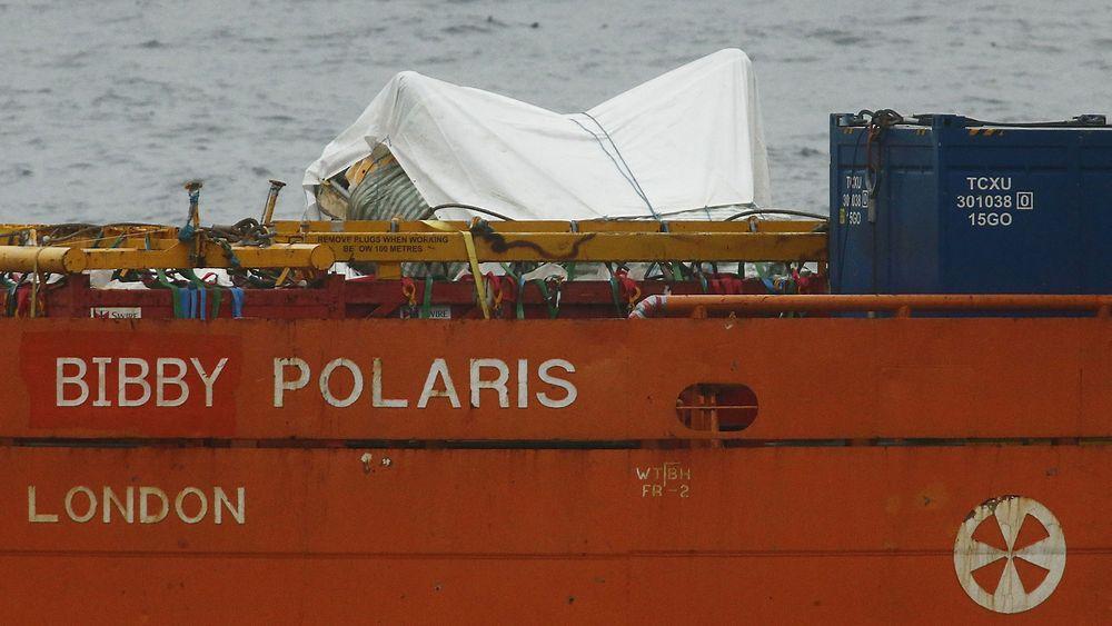 Tildekkede vrakdeler fra AS332L2-maskinen som havarerte utenfor Shetland fredag kveld, i ferd med å fraktes til land mandag formiddag. 