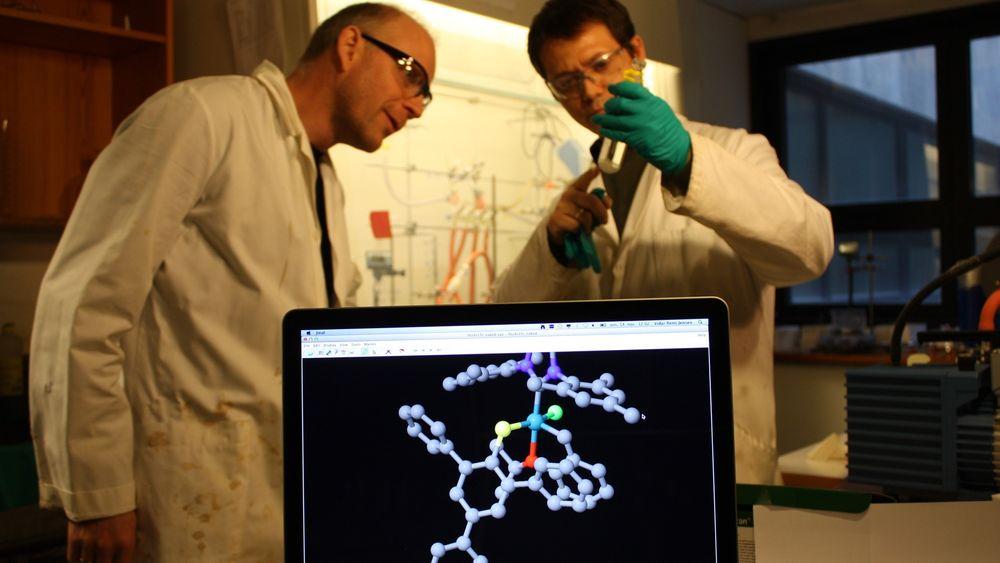 Professor Vidar R. Jensen sammen med forskerkollega Giovanni Occhipinti. På skjermen ser vi en molekylmodell av en av katalysatorene de har laget, med rutenium i blått i midten.  
