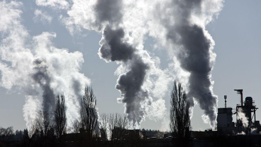 smoking chimney of an industrial company. Pollution and waste gases Klimaendringer. Global oppvarming. Illustrasjonsfoto 
