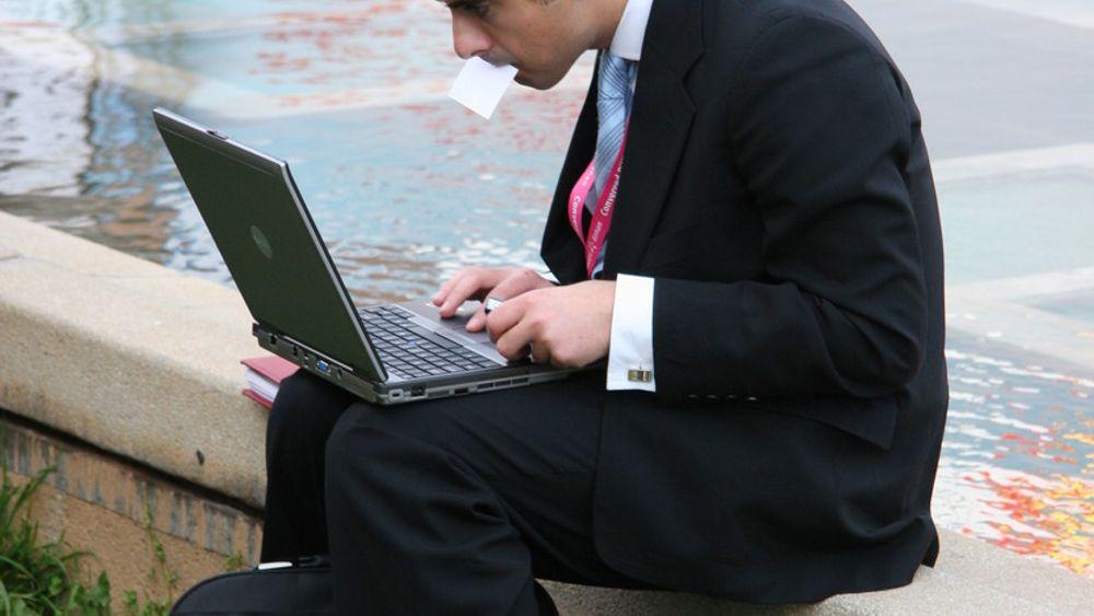 Businessmann og intens laptop-bruk.