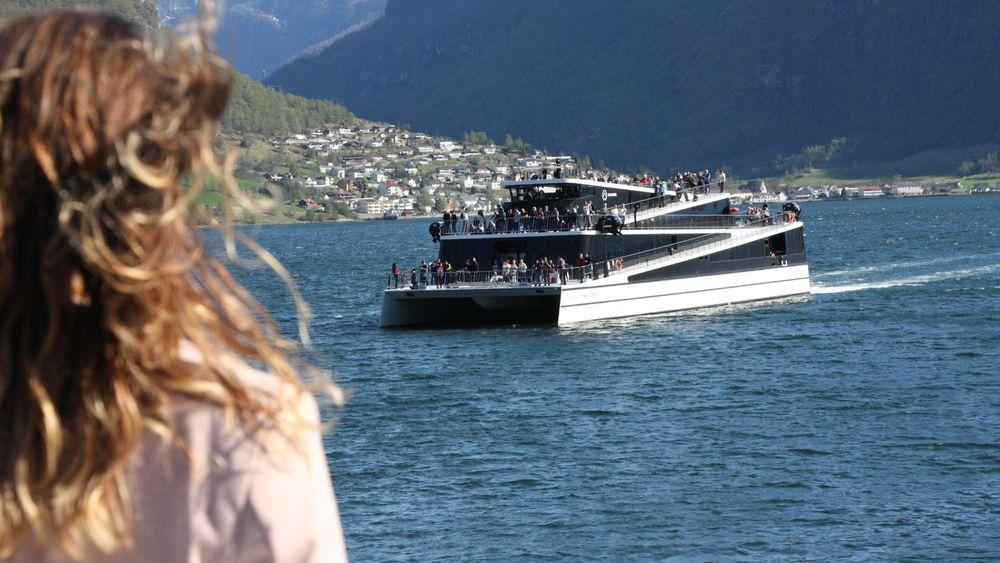 Future of the Fjords, som er 100 prosent elektrisk, møter hybridfartøyet Vision of the Fjords like ved Flåm i Aurlandsfjorden. Begge turistbåtene er bygget av Brødrene Aa i karbonfiber for The Fjords.